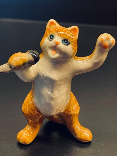 Porcelain Ginger Cat Singing with a Microphone.
