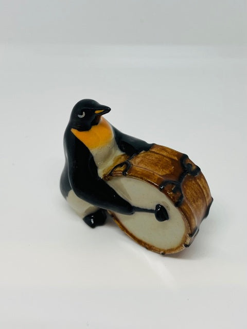 Porcelain Penguin Playing the Drum.