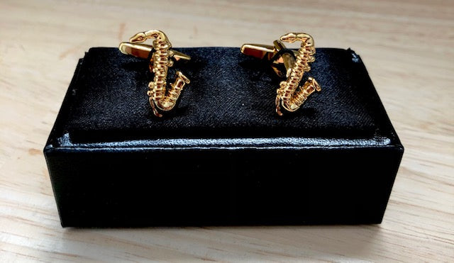 Gold saxophone cufflinks.